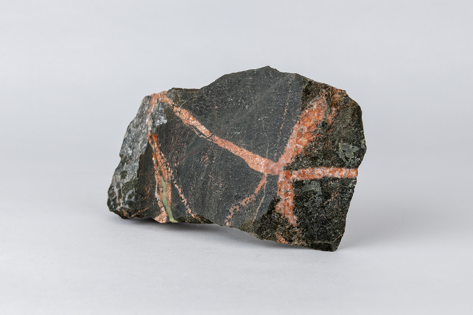 Intersecting veins of pink granite cutting dark metamorphosed sandstone, Glen Tilt (GLAHM:164042)